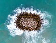 © Lansep - Aerial view of a rock breakwater amidst turquoise waves