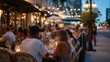 © Aliaksandr - Outdoor dining scene at night with people enjoying meals. Tables are set with glasses and plates. Warm lights illuminate the area, creating a cozy atmosphere.
