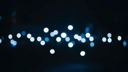 Defocused blue lights shimmering against dark background creating dreamy abstract bokeh effect in cinematic style seamless loop for festive and creative visuals