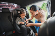 © geargodz - mother is fastening safety belt to toddler girl in car seat, safety baby chair travelling