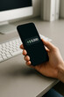 © Liliia - Close-up of a hand holding a modern smartphone with glowing green text “+5000” on the screen, concept of digital money transfer, mobile banking deposit, instant financial success.