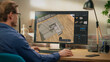 © Gorodenkoff - Male Interior Designer Using Professional 3D Modeling Software on a Computer to Create a Modern Living Room Layout with Sofa and a Table. Over the Shoulder Shot of a Creative Person at Work