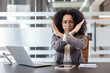 © Tetiana - Portrait of an African American businesswoman sitting at a desk in the office and showing a crossed-arms stop gesture to the camera