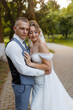 © Vasil - Couple embraces tenderly in a park during golden hour on their wedding day