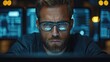 © Vectos - Focused face lit by screens with digital data behind