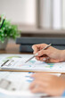 © Natee Meepian - Financial Review. Professional analyzing charts and graphs for strategic planning.