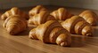 © Tri - A delightful arrangement of freshly baked golden croissants on a wooden surface, a warm and inviting breakfast pastry