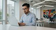© Tri - Dedicated Asian professional working diligently on a laptop computer at a desk, showcasing concentration in a modern business environment