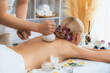 © InfiniteFlow - Hot herbal ball spa massage body treatment, masseur gently compresses herb bag on woman body. Tranquil and serenity of aromatherapy recreation in day lighting ambient at spa salon. Quiescent
