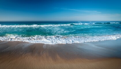 Wall Mural - ocean waves breaking on smooth shoreline with textured sand and vibrant blue water