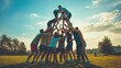 © Last - Group of men forming a human pyramid outdoors at sunset.