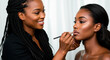 © Leo - African-American makeup artist applying makeup to a client