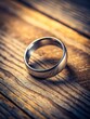 © TH - Close-up of a metallic ring resting on a wooden table with subtle texture and soft lighting effects