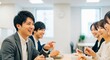 © Stingray_Japan - 笑顔あふれる交流、同僚と笑顔で食事をする若手社員たち