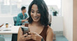 © peopleimages.com - Happy, phone and businesswoman in office with networking, communication or connectivity. Smile, technology and female editor with cellphone for contact or texting on mobile app on break in workplace