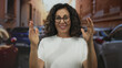 © Krakenimages.com - Middle aged hispanic woman in white tshirt spreads arms widely on urban street; welcome openness confidence hope.