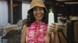 © Krakenimages.com - Woman smiling in restaurant holding lotion bottle, wearing bikini, lei and hat, indoors suggesting a summer vacation theme with tropical vibes and relaxation intent.