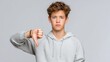 © Ireen - Teen boy giving thumbs down with disappointed face negative feedback isolated