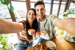 © Davide Angelini - Happy couple enjoying breakfast drinking coffee at bar cafeteria - Life style concept with guy and girl in love having date moment sitting at restaurant in the city centre