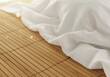 © Ryota - 優雅に広がる白い布、光輝く竹のマット
