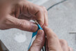 © lunika - two hands are carefully stripping insulation from wires in workshop, demonstrating precision and focus on task preparing cables for electrical connections. close up.
