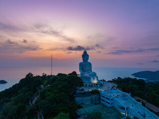 Wall Mural - An impressive and serene Buddha statue stands tall, representing peace and spirituality. The statue is surrounded by sweet atmospheric , enhancing its tranquil presence against a clear sky.