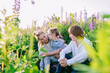 © Iryna - Child with Down syndrome sitting with teacher and peer among wild lupines