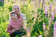 © Iryna - Mother and daughter with Down syndrome sitting in lupine meadow