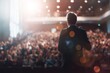 © RICH - Speaker delivering speech on stage with microphone to audience under spotlight at conference, leadership concept