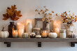 © Seema - Warm autumn mantelpiece decor with flickering candles, pumpkins, and fall leaves creates cozy seasonal ambiance for home.