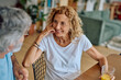 © we.bond.creations - Happy senior woman enjoying breakfast at home, listening to her husband while sharing smiles and engaging in warm conversation together