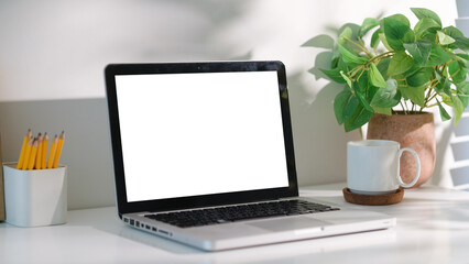 Wall Mural - Laptop with blank white screen on modern desk, perfect for mockup or design presentation.