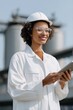 © Andrii Zastrozhnov - Smiling african female engineer in hard hat using tablet at industrial plant