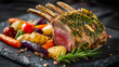 © KRNO - Gourmet lamb rack with fresh herb crust served with colorful roasted vegetables on slate plate closeup