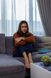 © David - Asian woman feeling stress and headache on sofa. She used her hand to touch her face she has a headache sitting on sofa couch in living room at home.