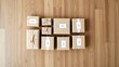 © XIN KONG - Minimalist arrangement of package boxes on wood, showcasing a clean e-commerce concept.