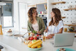 © Dorde - Young Women Friends Cooking Together in a Bright Modern Kitchen Using Fresh Ingredients