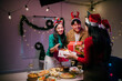 © Parichat - Friends exchanging Christmas gifts during a festive dinner party
