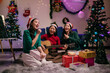 © Parichat - Asian women singing christmas carols playing guitar at home