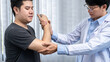 © Ngampol - Young asian physiotherapist giving assistance to man patient with elbow injury
