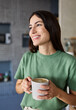 © Lumos sp - Portrait of a young woman drinkng coffee in kitchen