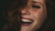 © Wida - Close-up portrait of a woman with freckled skin, laughing joyfully with her mouth wide open, showcasing her bright, healthy teeth, in a warm, inviting light.