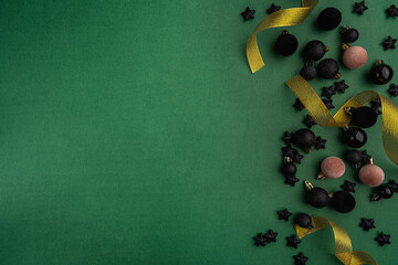 Wall Mural - chic black baubles, stars, and golden ribbon frame a green background, creating a bold and modern ho