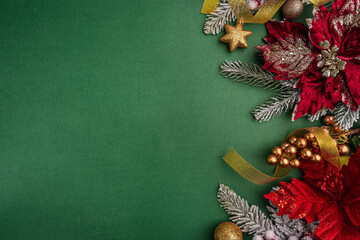 Wall Mural - festive red poinsettias, gold ornaments, and pine branches decorate the right side of a green backgr
