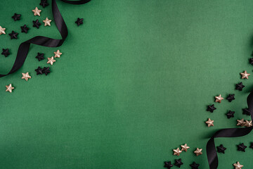 Wall Mural - chic black baubles, stars, and golden ribbon frame a green background, creating a bold and modern ho