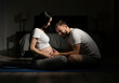 © Vasiliy - Pregnant couple touching belly together in bedroom with dramatic lighting. Prenatal bonding and partnership support during pregnancy for family lifestyle content