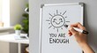 © StockShift - Hand drawing a happy sun and inspirational message 'you are enough' on whiteboard