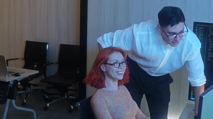 Two developer or programmer colleagues collaborating on programming and data analysis using monitors. They discuss code review system logs and share ideas in a modern office. Teamwork and technology.