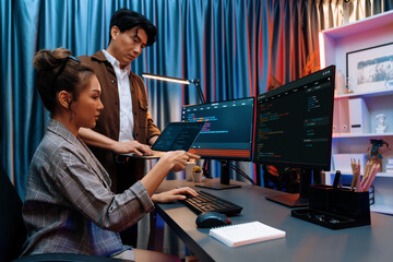 Serious of IT developers discussing intelligent website development coder system running data online two screens with laptop showing information network at neon light room at modern office. Infobahn.