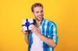 © be free - Mens day. Party present. Man on February 14. Caucasian guy hold present box for Valentines day. Happy holiday. Man with gift isolated on yellow. Birthday gift. Party on mens day